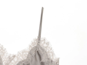 Detail of grey satin camisole featuring delicate eyelash lace trim and silk texture