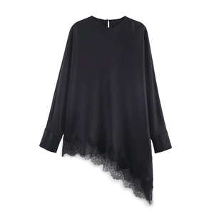 Detail of elegant black satin blouse with asymmetric hem and eyelash lace trimming