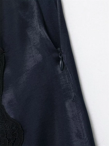 Détail d'une jupe en satin bleu foncé avec fermeture éclair cachée et dentelle noire
