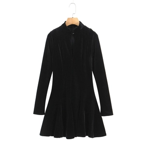 Detail of a black velvet long sleeve dress featuring a standing collar and V-shaped cutout