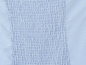 Detailed view of blue and white striped fabric with elastic smocking textures