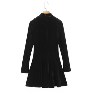 Close-up of black velvet dress featuring a high collar, long sleeves, and a slim fit cut