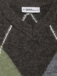 Dettaglio macro della maglia a rombi e etichetta del brand con taglia S