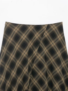 Detail view of brown and black plaid skirt waist featuring classic twill pattern texture
