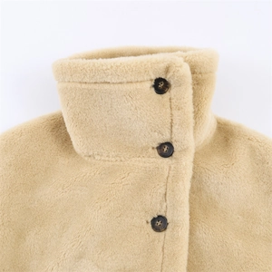 Detailed macro view of standing collar and tortoiseshell buttons on beige plush winter jacket