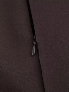 Detaillierte Makroansicht des hochwertigen verdeckten Reißverschlusses am braunen Kleid