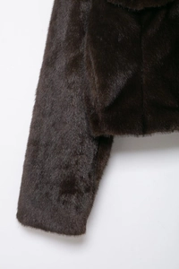 Detail shot of plush dark brown faux fur texture with high sheen and premium stitching