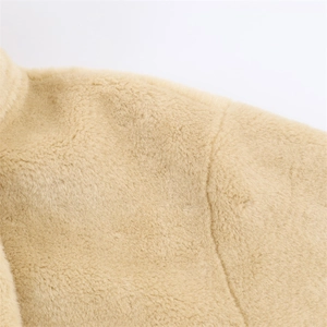 Detailed close-up showing soft beige faux fur material on this winter fashion jacket