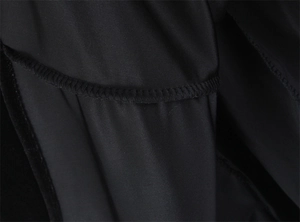 Macro shot showing high-quality overlock stitching and fabric texture on a black dress