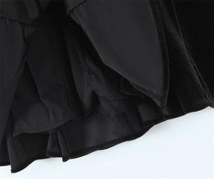 Close-up of black velvet dress hem showing multi-layer construction and smooth lining