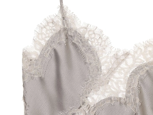 Close-up of silk satin camisole featuring delicate floral lace trim and eyelash edges