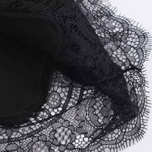Close-up of delicate black eyelash lace trim and floral mesh detail on long sleeve top