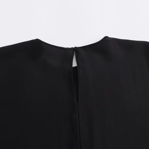 Close-up of black crew neck top featuring a stylish keyhole cutout and neat stitching