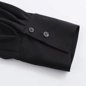 Detail of black long sleeve cuff with pleated texture and two parallel buttons
