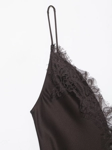 Close-up of the black satin fabric with intricate eyelash lace trim and thin straps