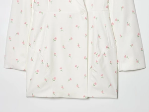 Détail de la veste blazer blanche à fleurs avec revers et motif floral rose