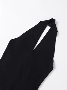 Detail of slim fit black halter knit top featuring a deep V-neck and fine texture
