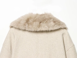 Detail of beige winter coat featuring luxurious faux fur collar and wool-like texture
