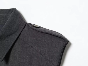 Close-up of lapel collar and shoulder epaulette detail on dark gray sleeveless dress