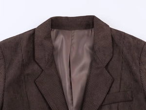 Macro detail of dark coffee corduroy blazer collar and smooth inner lining fabric