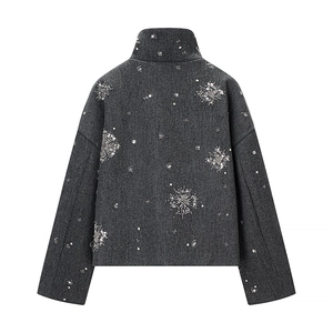 Detailed back view of dark grey jacket featuring intricate silver sequin snowflake patterns
