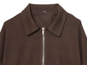 Detailed macro view of dark brown twill wool jacket with silver metal zipper closure