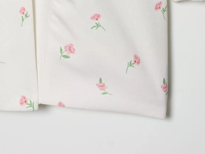 Détail macro d'imprimé floral rose et texture tissée sur tissu de blazer blanc