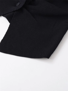 Macro shot of high-density black knit fabric with matching fabric-covered button detail