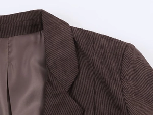 Detail view of corduroy blazer lapel showing fine ribbed texture and premium brown lining