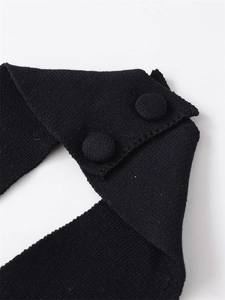 Close-up of fabric-covered buttons and fine texture on a black oversized knit sweater