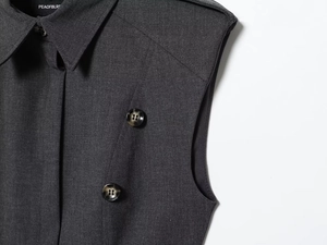 Macro detail of dark grey sleeveless dress showing lapel collar and marble texture buttons