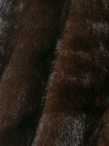 Macro texture of dark brown faux fur showcasing smooth shiny fibers and thick luxury pile