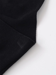 Macro detail of high-quality black knit fabric showing premium texture and stitching