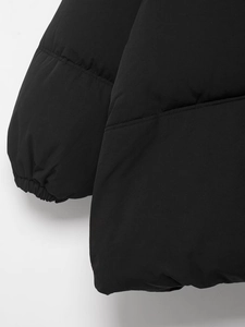 Détail des poignets élastiques et des coutures matelassées d'une veste d'hiver noire
