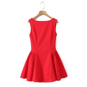 Detail of red sleeveless pleated dress with a-line hem hanging on a wooden hanger