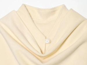 Close-up of beige wool coat collar with shawl lapel and matching button detail