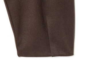 Close-up of dark brown twill fabric showing high-quality stitching on the cuffs and hem