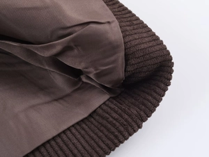 Detailed close-up of dark brown ribbed cuff and smooth satin lining of the winter blazer