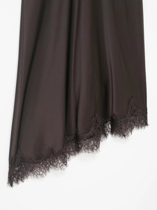 Detailed view of asymmetric satin dress hem with delicate eyelash lace trim detail