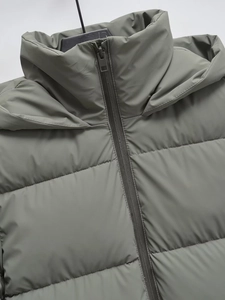 Dettaglio della giacca invernale con cappuccio, collo antivento e texture trapuntata opaca