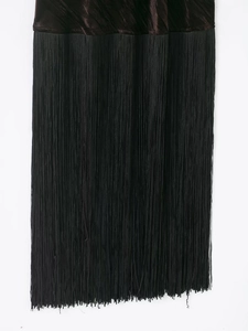 Vue détaillée du tissu en velours avec de longues franges noires sur une robe midi
