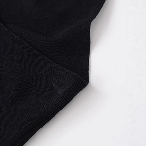 Close-up of high-quality black knit fabric showing detailed stitching and premium texture