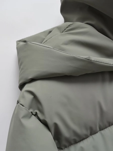 Dettaglio della cucitura del cappuccio e tessuto opaco antivento del parka verde