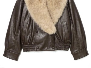 Détail d'une veste en simili cuir marron foncé avec un large col en fausse fourrure beige