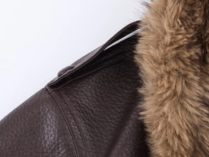 Détail d'une veste en similicuir marron foncé avec col en fourrure et texture