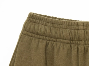 Detailed macro view of olive green elastic waistband with neat reinforced stitching