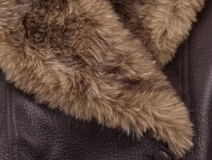 Gros plan d'une veste en similicuir marron foncé avec col épais en fausse fourrure