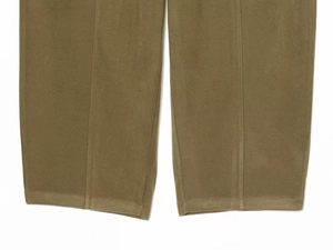Detail of tan corduroy pant hem featuring vertical stitched seams and soft texture