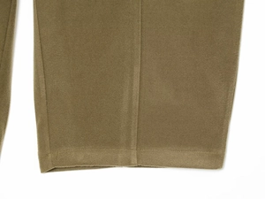 Close-up of the fine stitching and matte velvet texture on olive green trouser cuffs