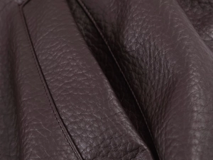 Vue macro d'une veste en similicuir marron foncé avec grain détaillé et coutures précises
